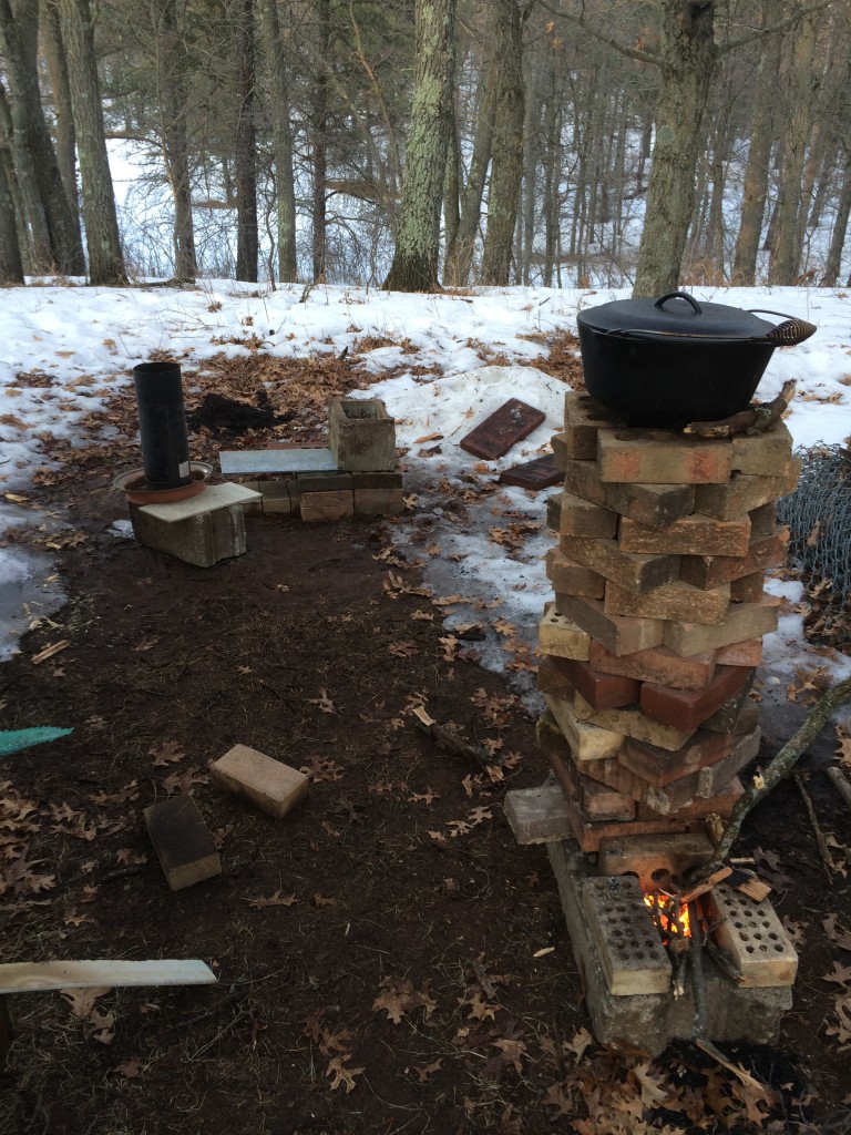 rocket stove 1.0 in action with 2.0 being built in the background