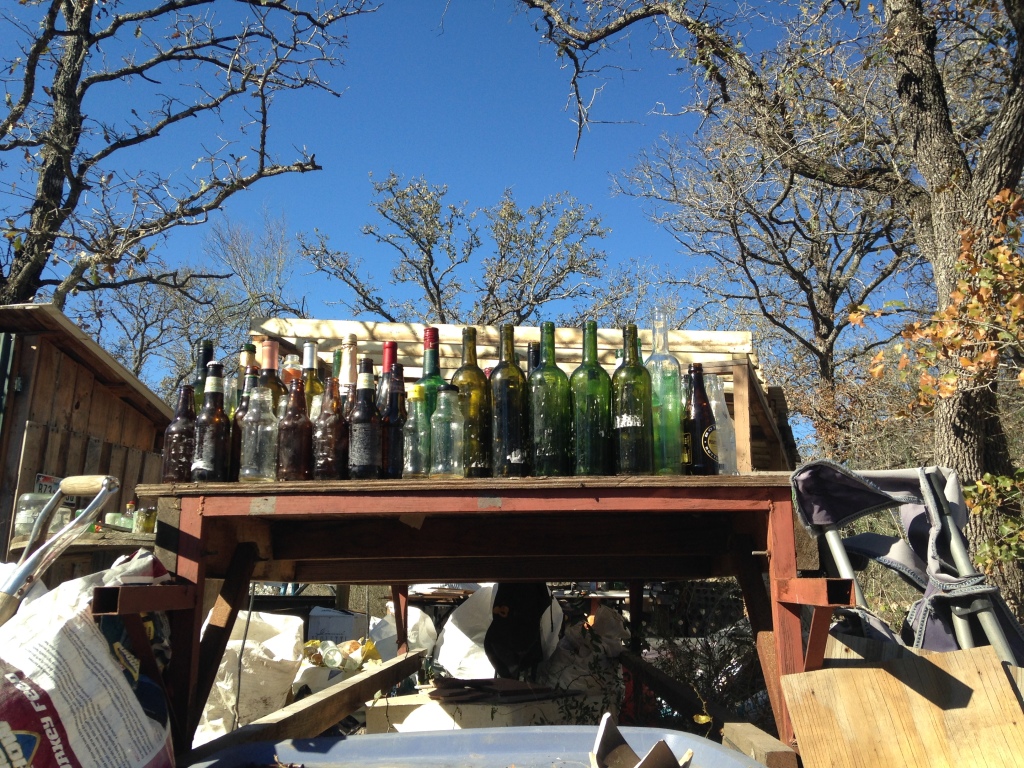 bottles awaiting de-labeling, halving, taping, and mortaring into the bottlehouse walls