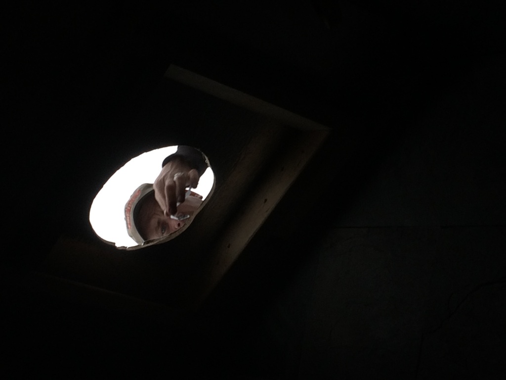 Shane peers through the new hole in his home's roof, in the midst of the wood stove installation (oops this pic is actually from the last days of December)