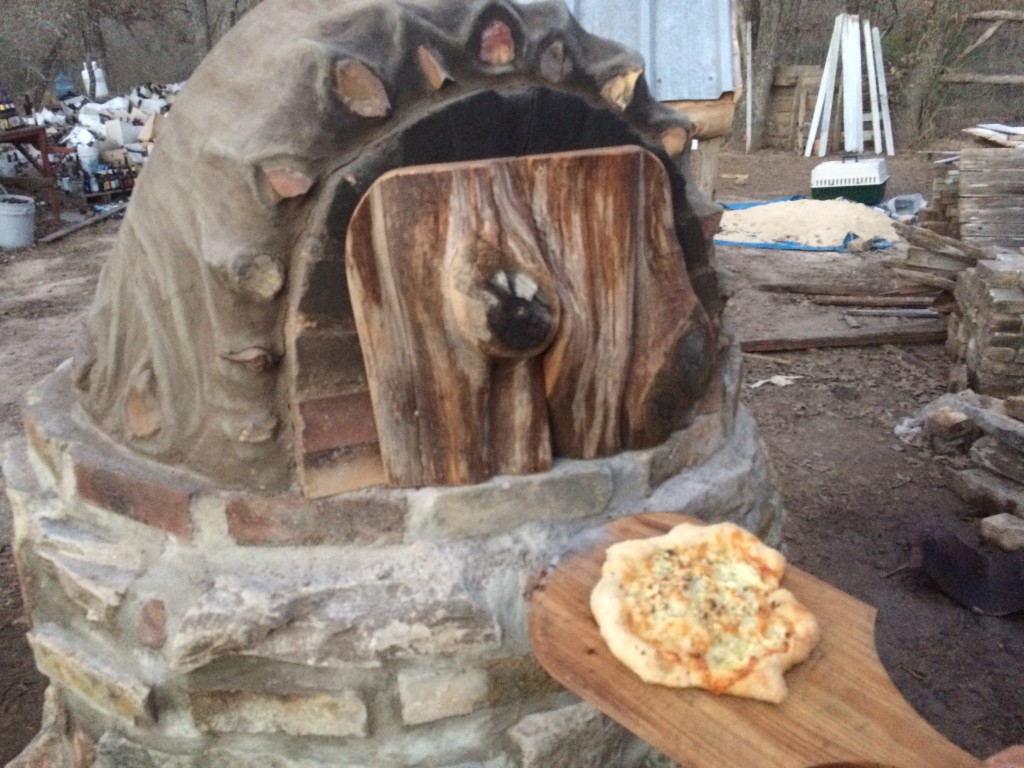 first pizza emerges!! (We got better at shaping the subsequent five pizzas, which had various combinations of bacon, caramelized onions, mushrooms, herbs, garlic, cheeses, pickled jalepenos ...)