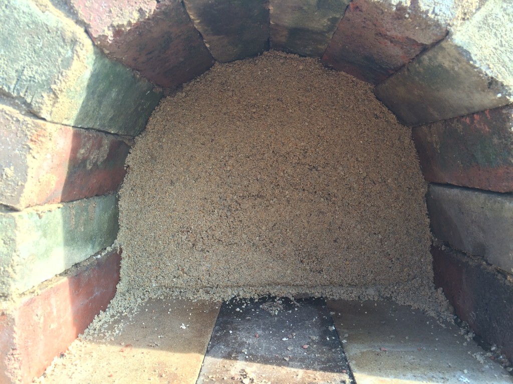 sand behind the arch form - we let it sit open to help the oven mud dry out more from within