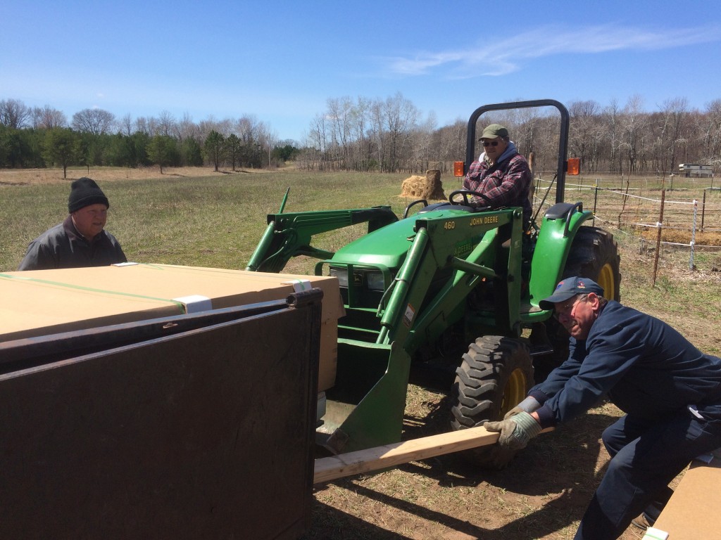 it takes a village to raise a farm! Jim Sehr, Neighbor Dave, and the truck driver helping unload the giant delivery of the future high tunnel greenhouse