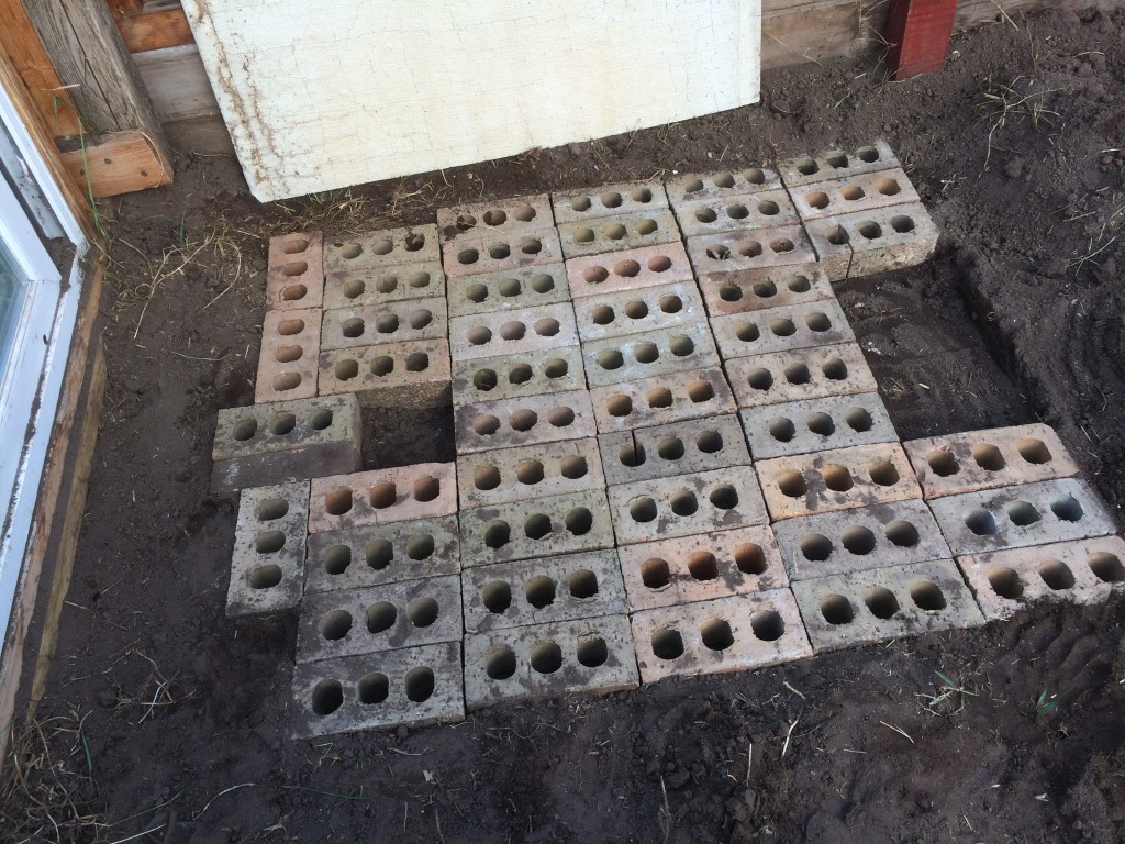 creating the subsurface foundation for the combustion chamber - the air spaces in the bricks add insulation to keep heat where it's wanted - not absorbing into the ground