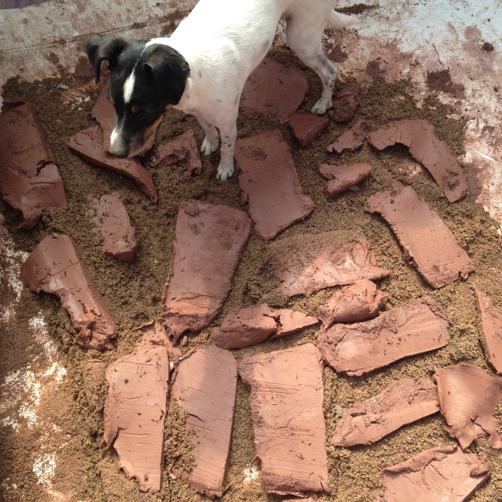 Kristin developed a technique of slicing off slabs of clay and spreading them out on the sand, then topping that with more sand, before starting to stomp and twist. 