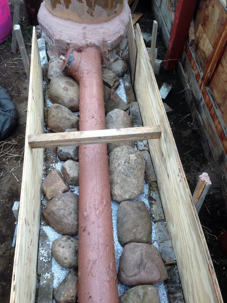 Exhaust duct was coated in clay slip for maximum heat transference. We tried to use as much river rock as we could to save on clay and sand, but it still took an incredible amount to fill the bench (23' long, 14" high, and 24" wide - wider where the forms bowed out)