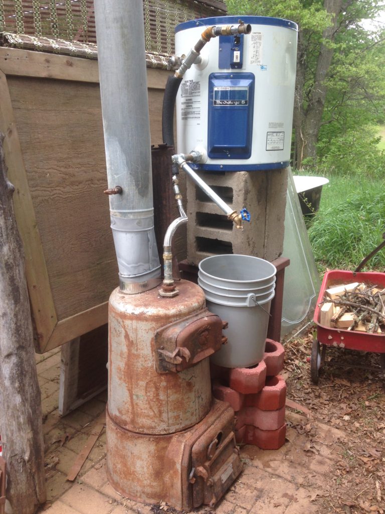 the wood-fired water heater, ready to provide up to 20 gallons of hot water every day. Made from a 1930's Sears "bucket-a-day" coal boiler and a modern Sears water heater tank. The fire and gravity work together to circulate the water without a pump.