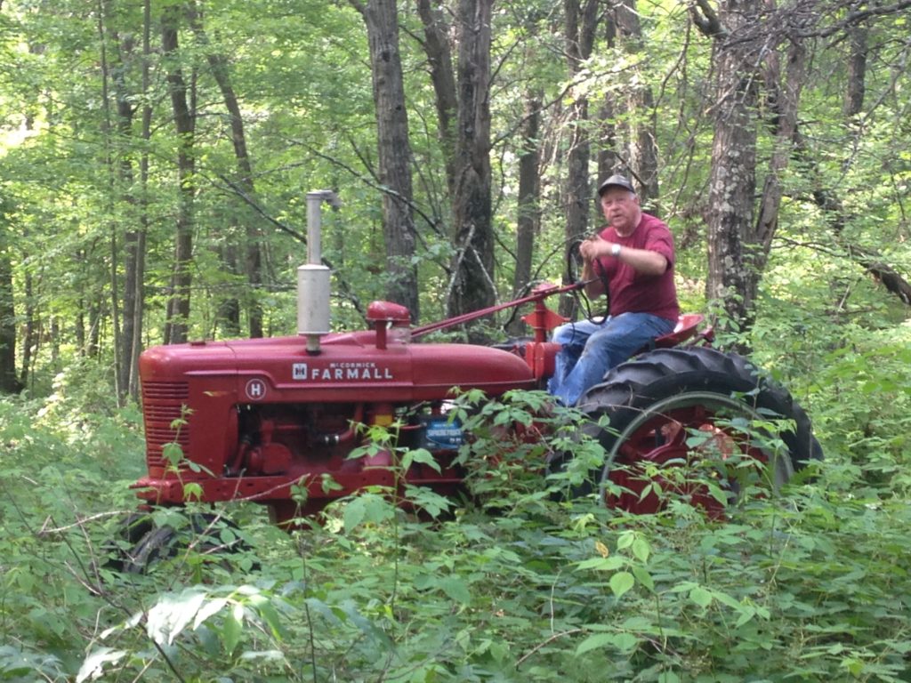 Jim pilots his tractor through the woods