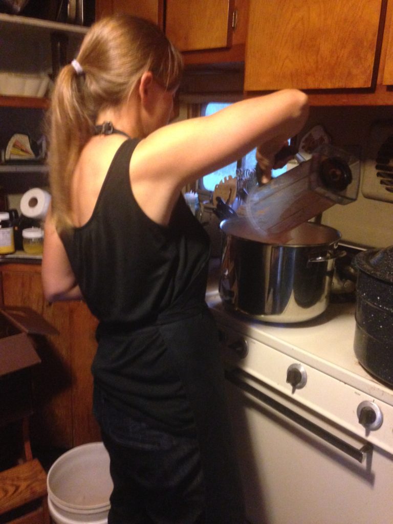 Kristin witchcrafting a potion of foraged feral apples and wild choke cherries