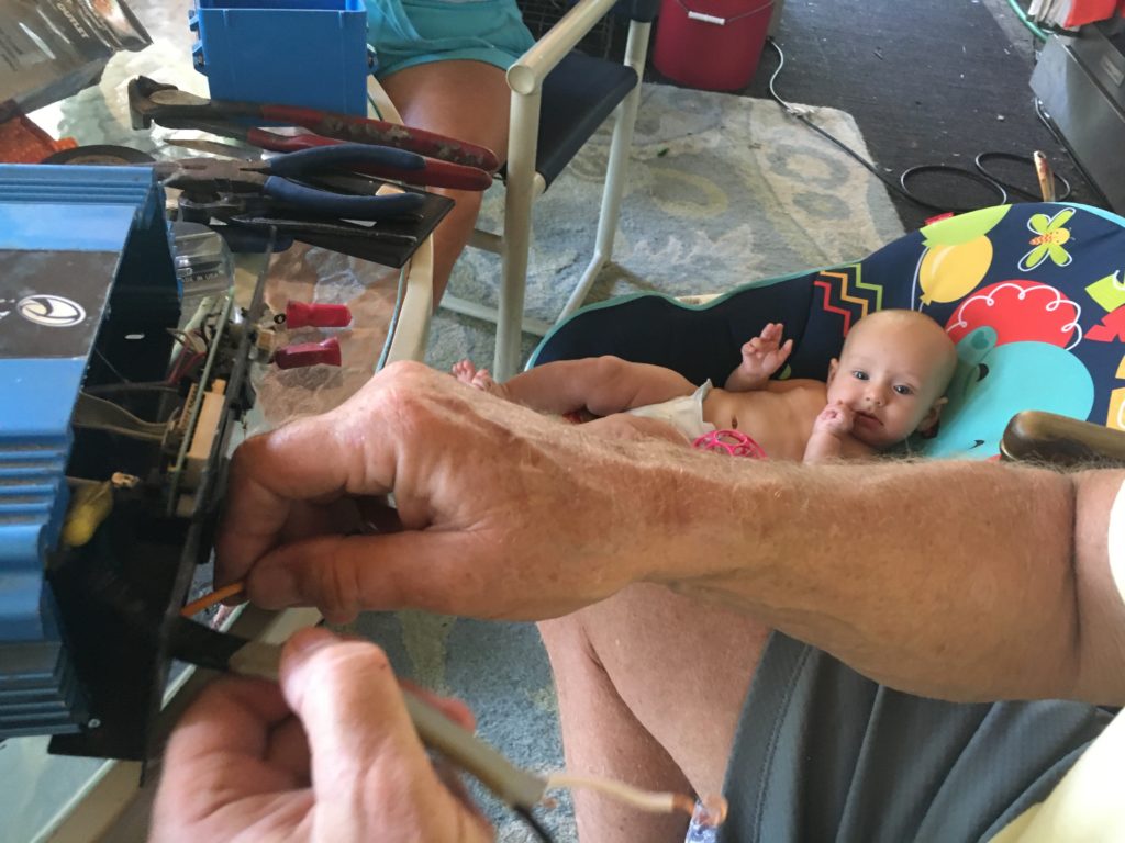 Otis watches Grandpa Ger repairing the defective outlet on our inverter